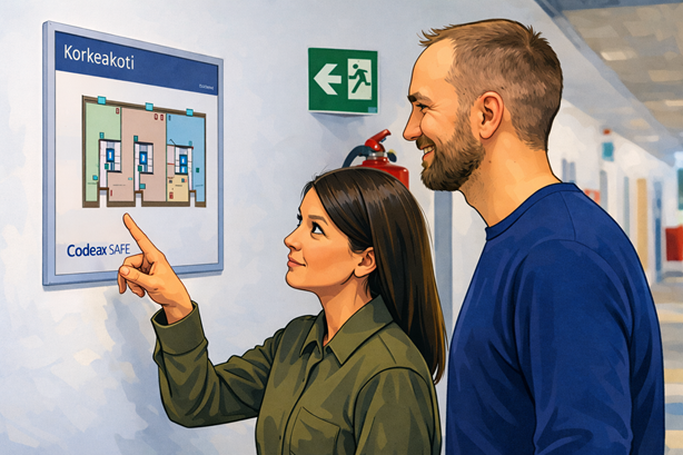 Kaksi henkilöä tarkastelee käytävän seinällä olevaa rakennuksen turvallisuuspiirrosta